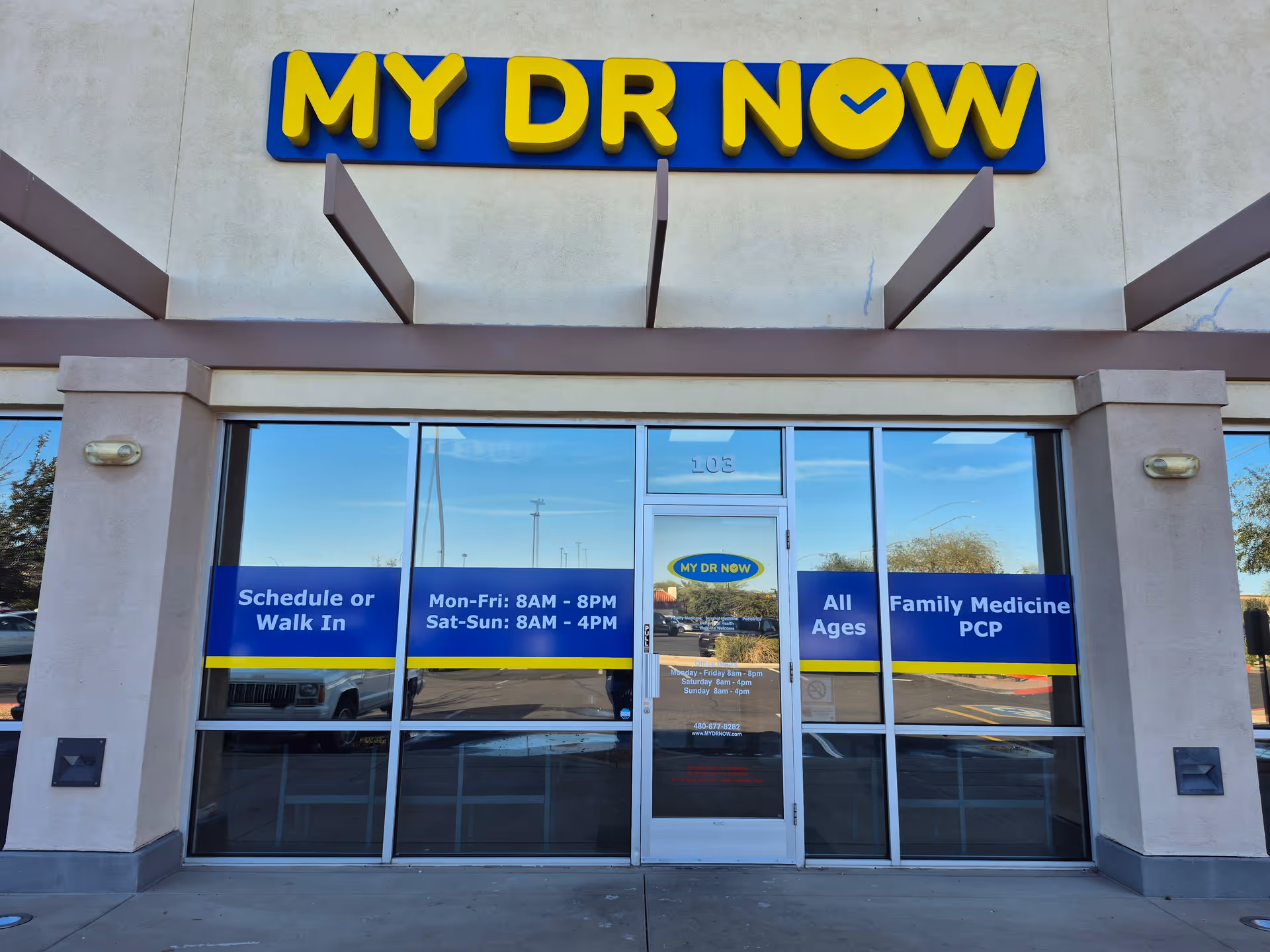 Front view of a My Dr Now clinic with glass doors and blue signage.