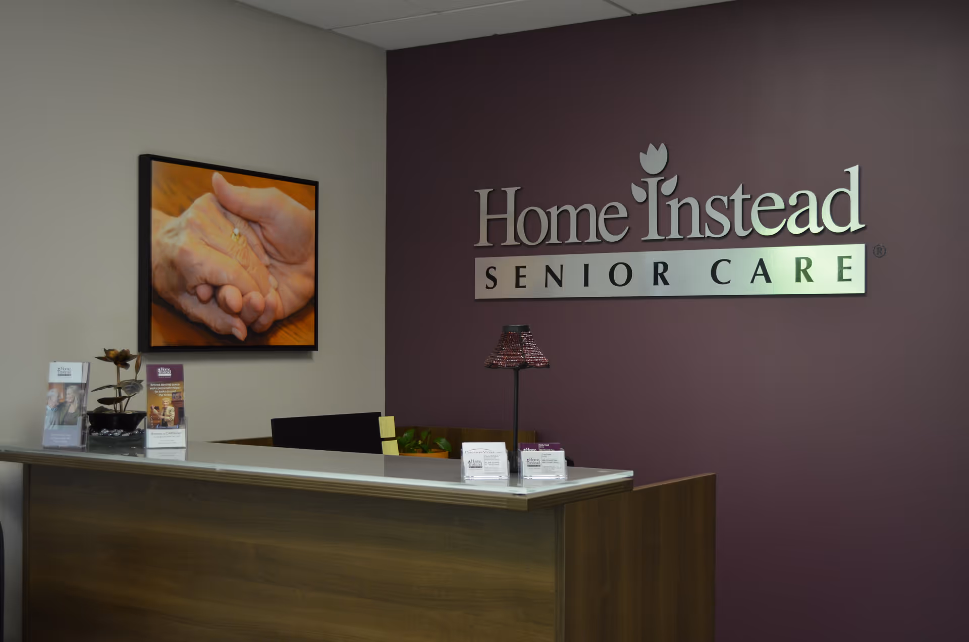 Reception desk in a Home Instead Senior Care lobby with logo.
