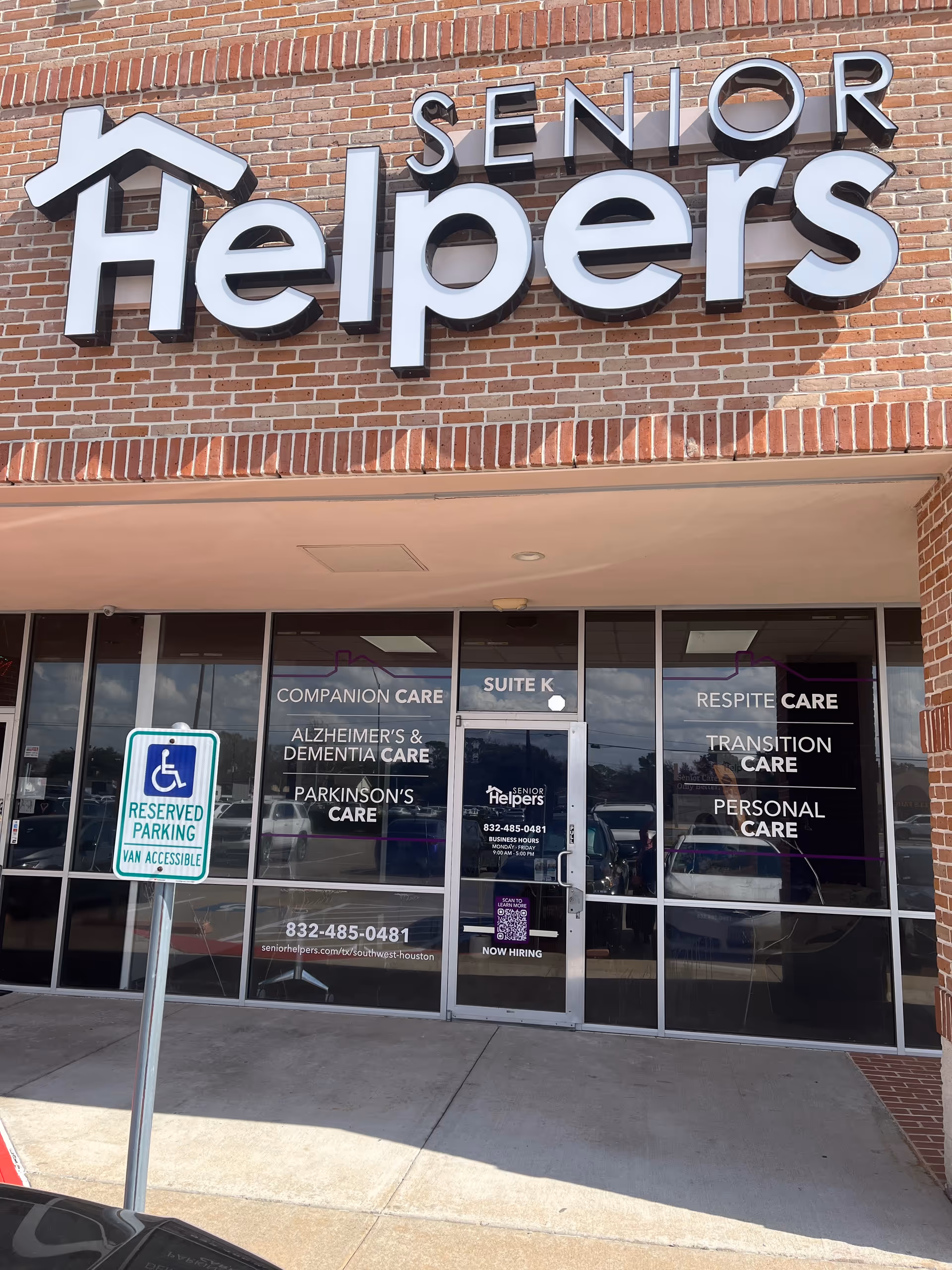 Exterior view of Senior Helpers storefront with glass doors, signage, and reserved parking.