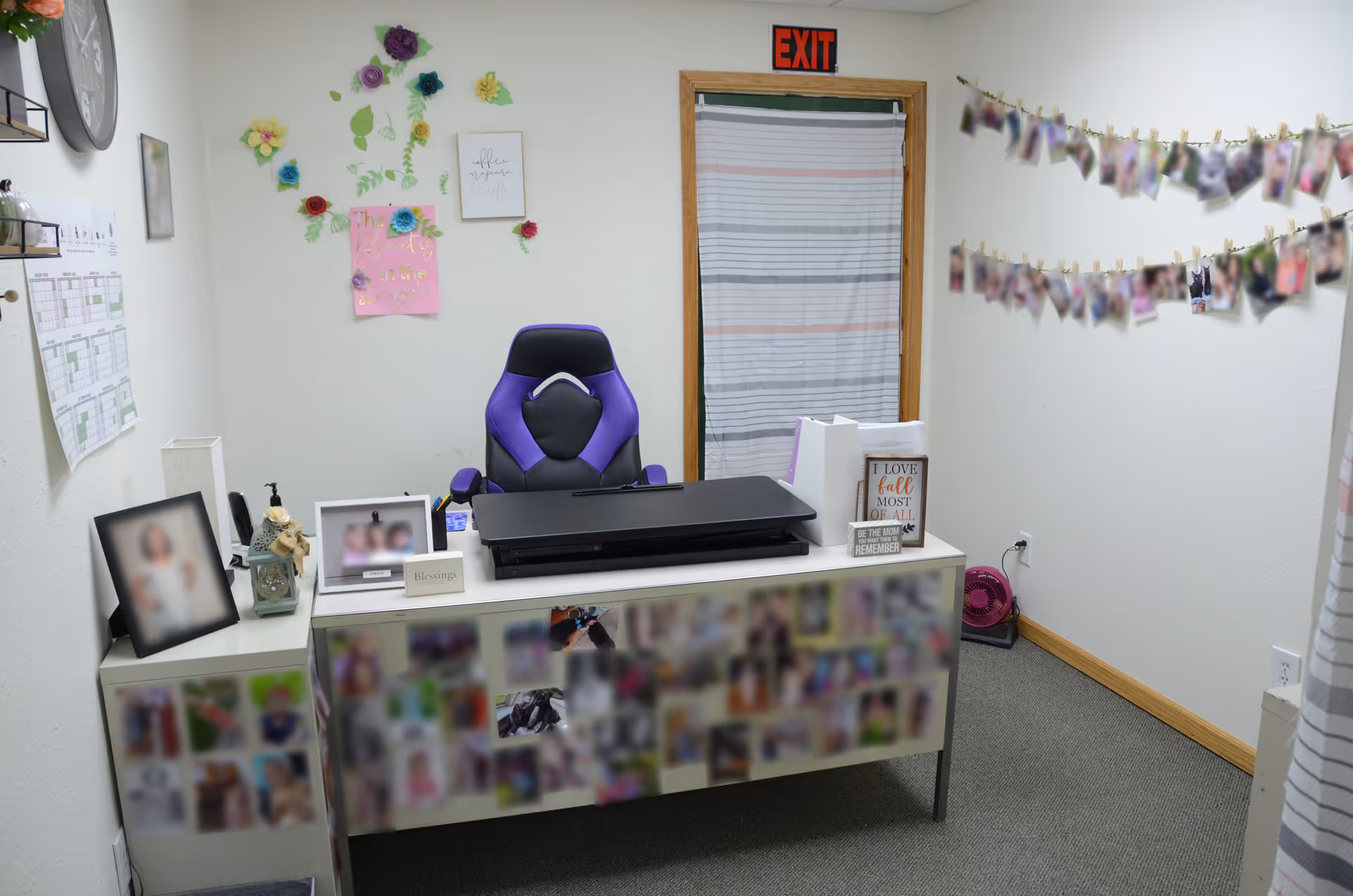 Reception desk at Serenity Point Hospice, LLC, with photos, purple chair, and wall decorations.