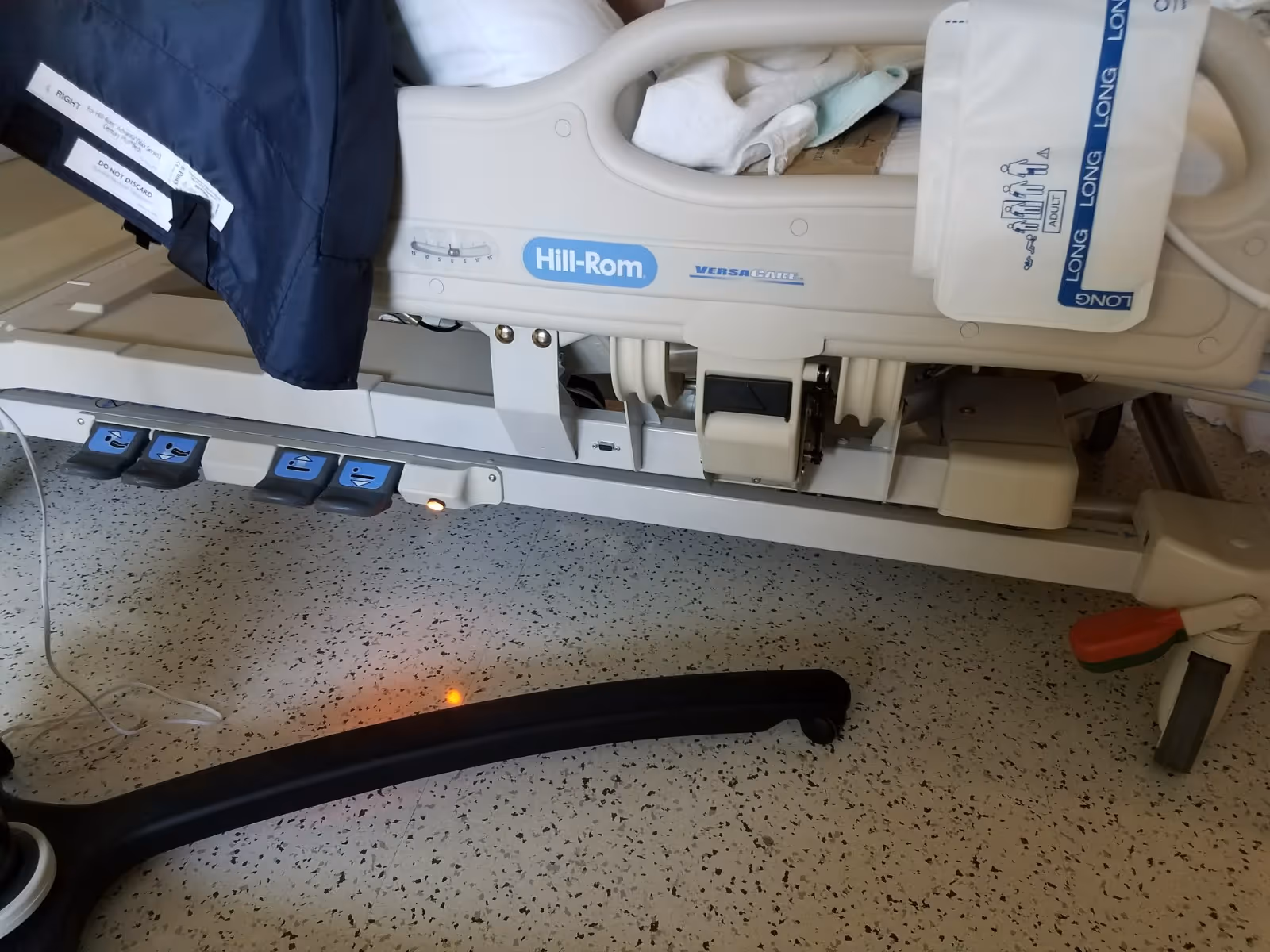 Hospital bed with side rails and medical equipment inside a patient room.
