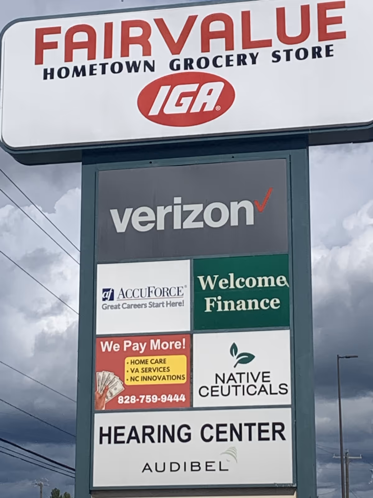 Outdoor building-front signboard displaying multiple business logos and advertisements.