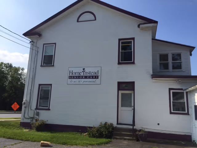 White two-story senior care building with a Home Instead sign on the front.