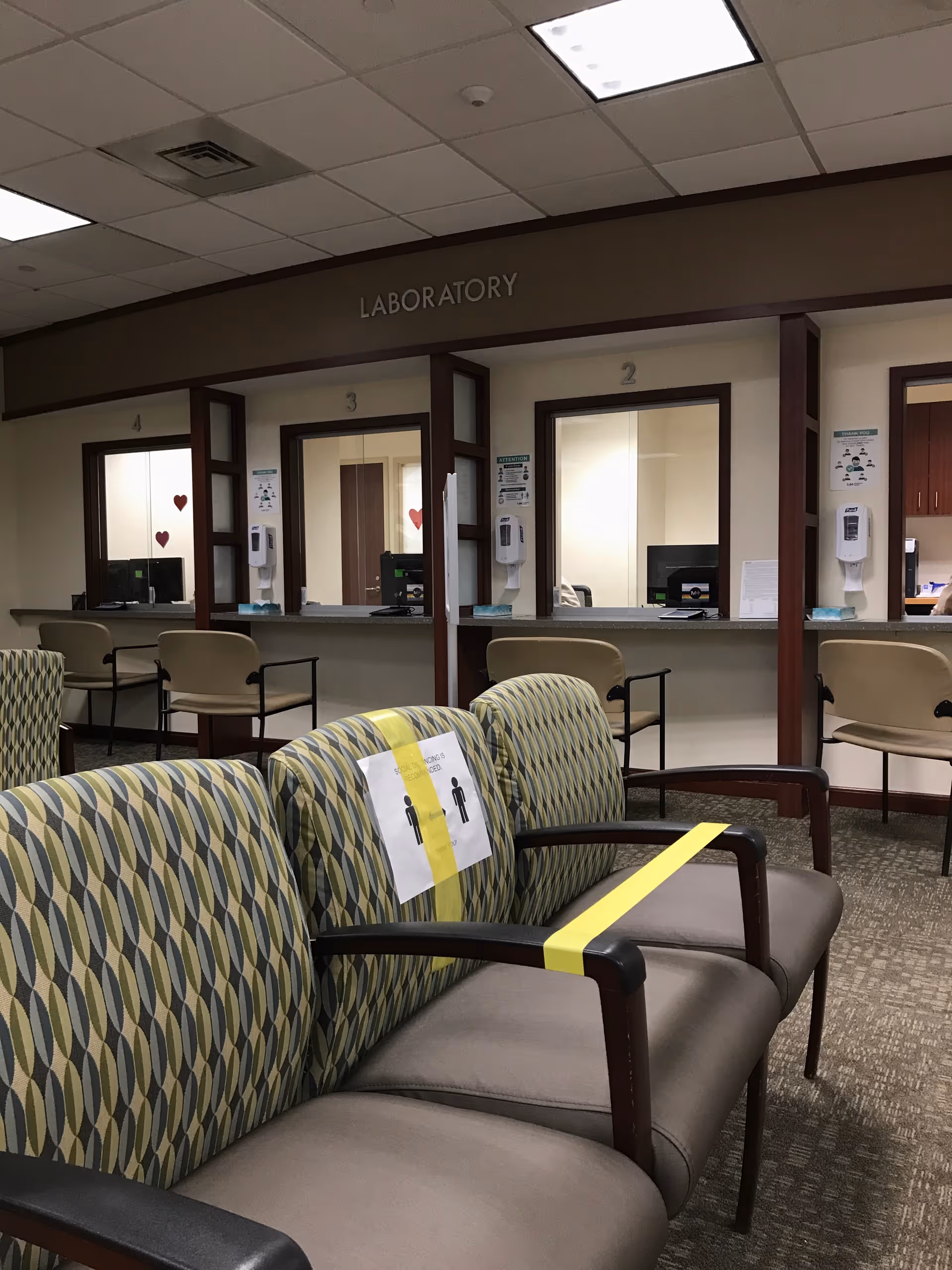 Waiting area with patterned chairs in front of a laboratory service desk.