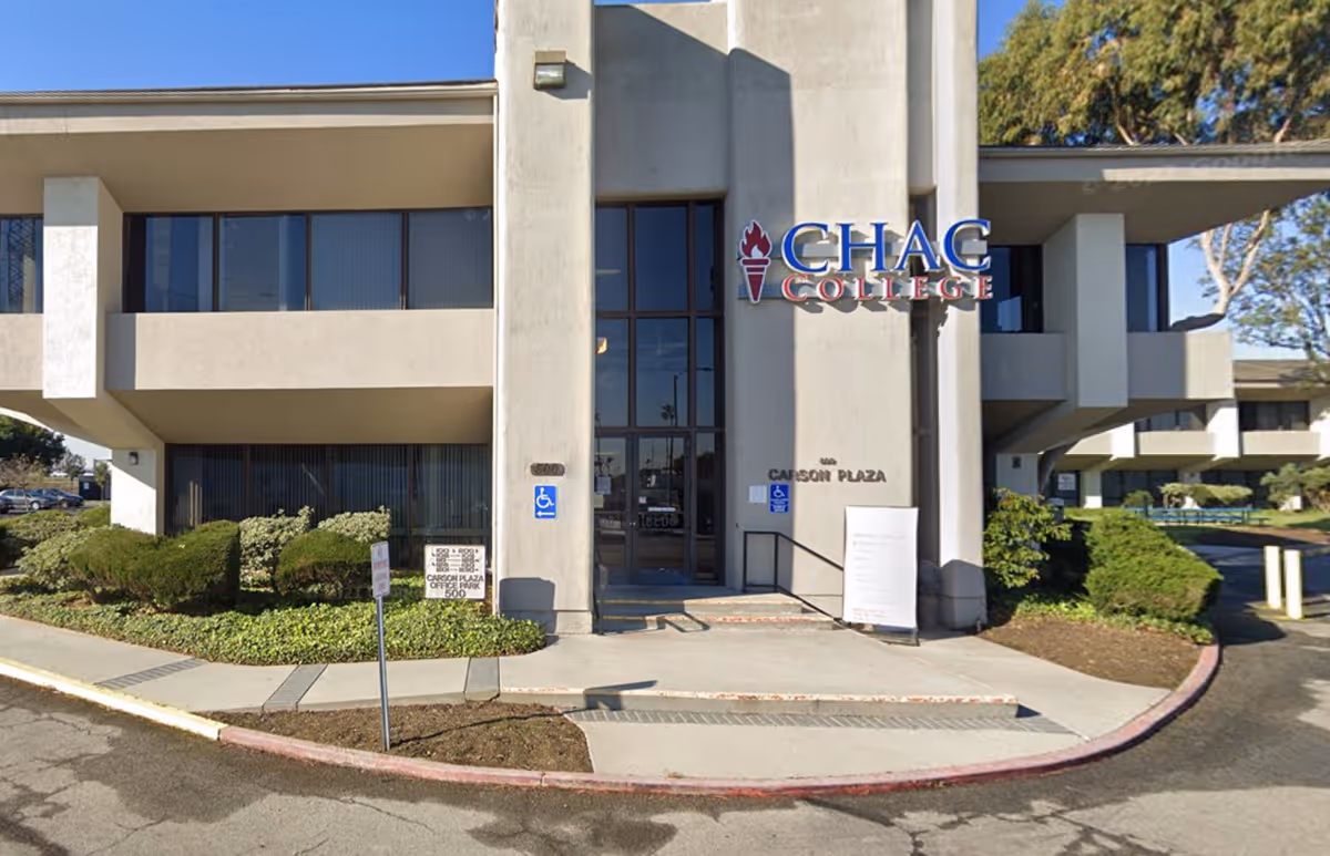Exterior view of a modern building entrance with CHAC College signage and surrounding landscaping.