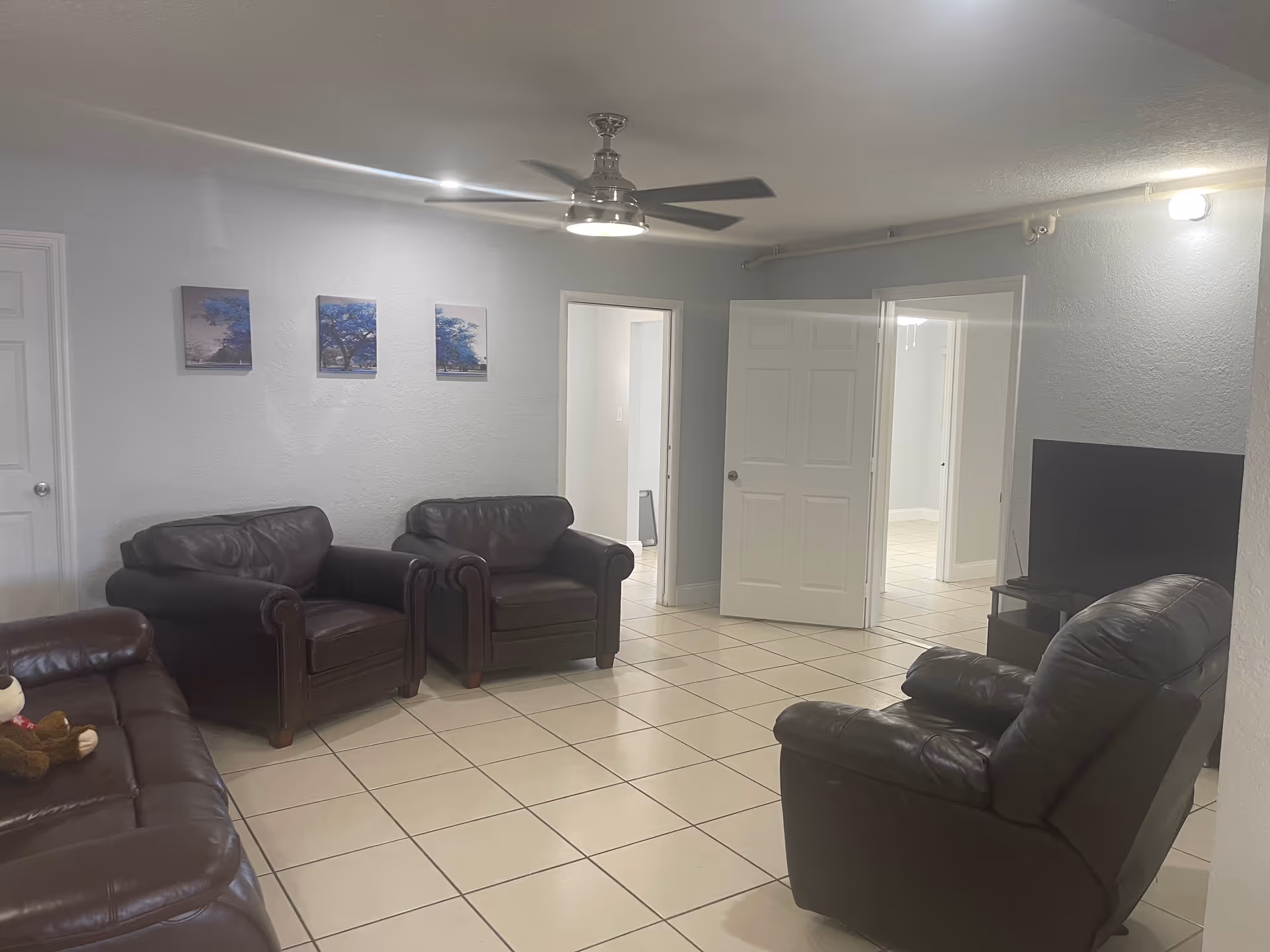 Mary's Love & Care Home lounge with leather seating, a TV, and tiled floor.