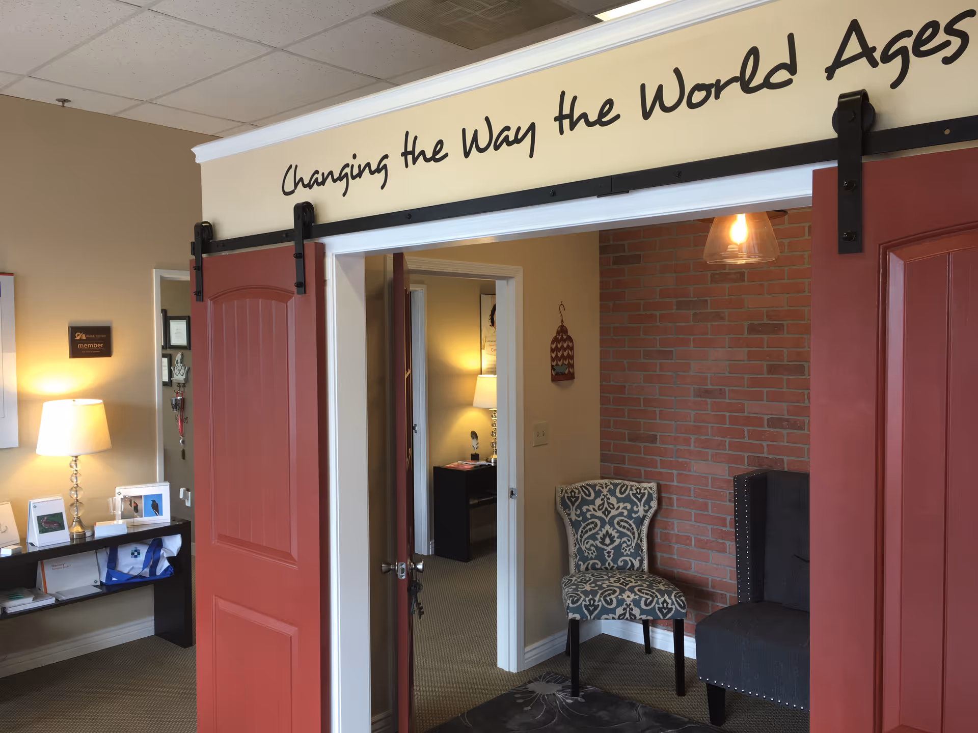 Interior reception area of a senior home facility featuring red sliding doors and seating.