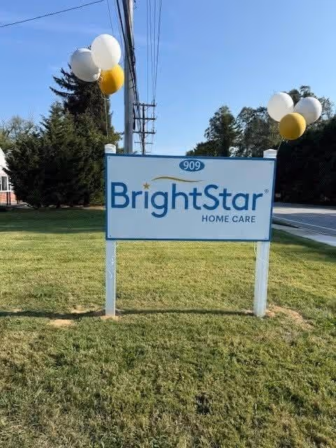 BrightStar Home Care sign on a grassy lawn with balloons near a road