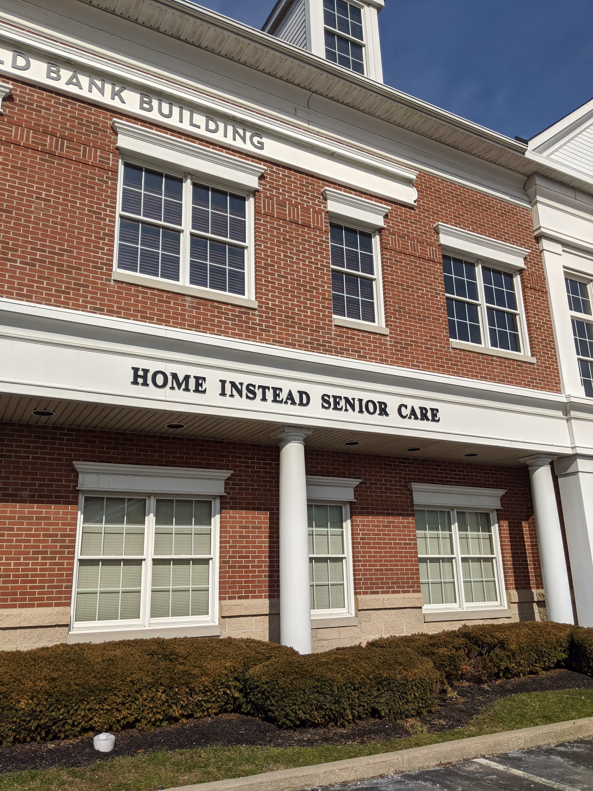 Brick building exterior with Home Instead Senior Care sign and entrance columns.