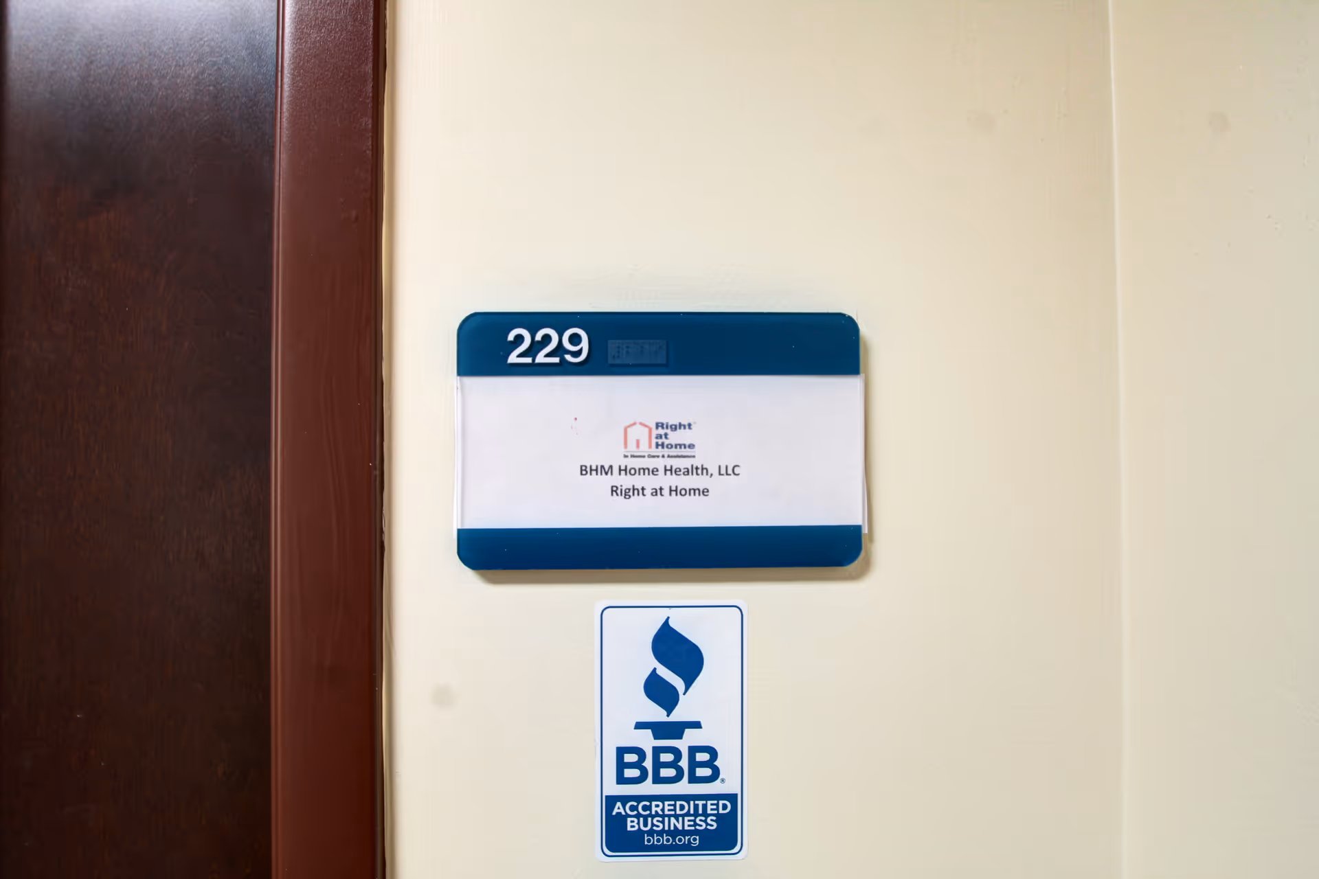 Door plaque showing room 229 with Right at Home sign and BBB sticker.