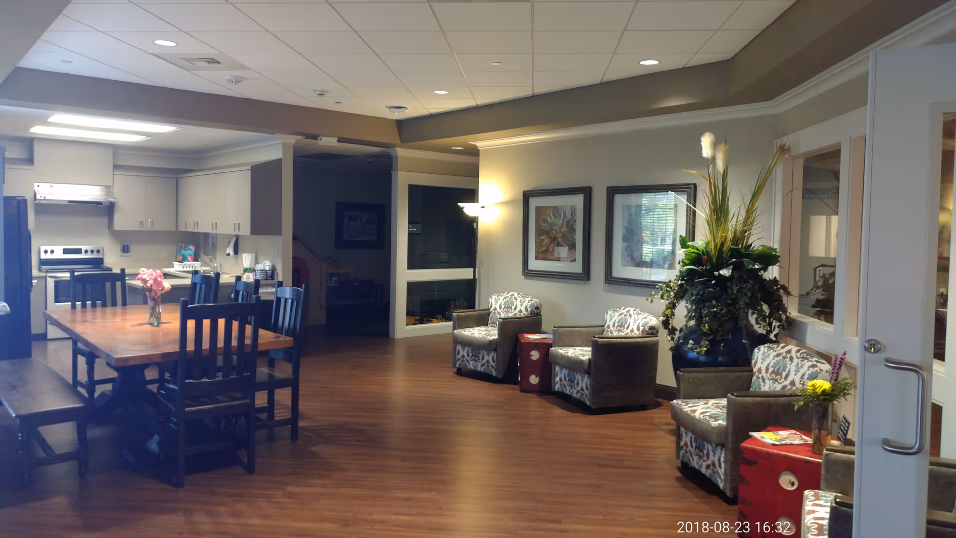 Interior common area with a dining table, kitchen, and lounge seating.