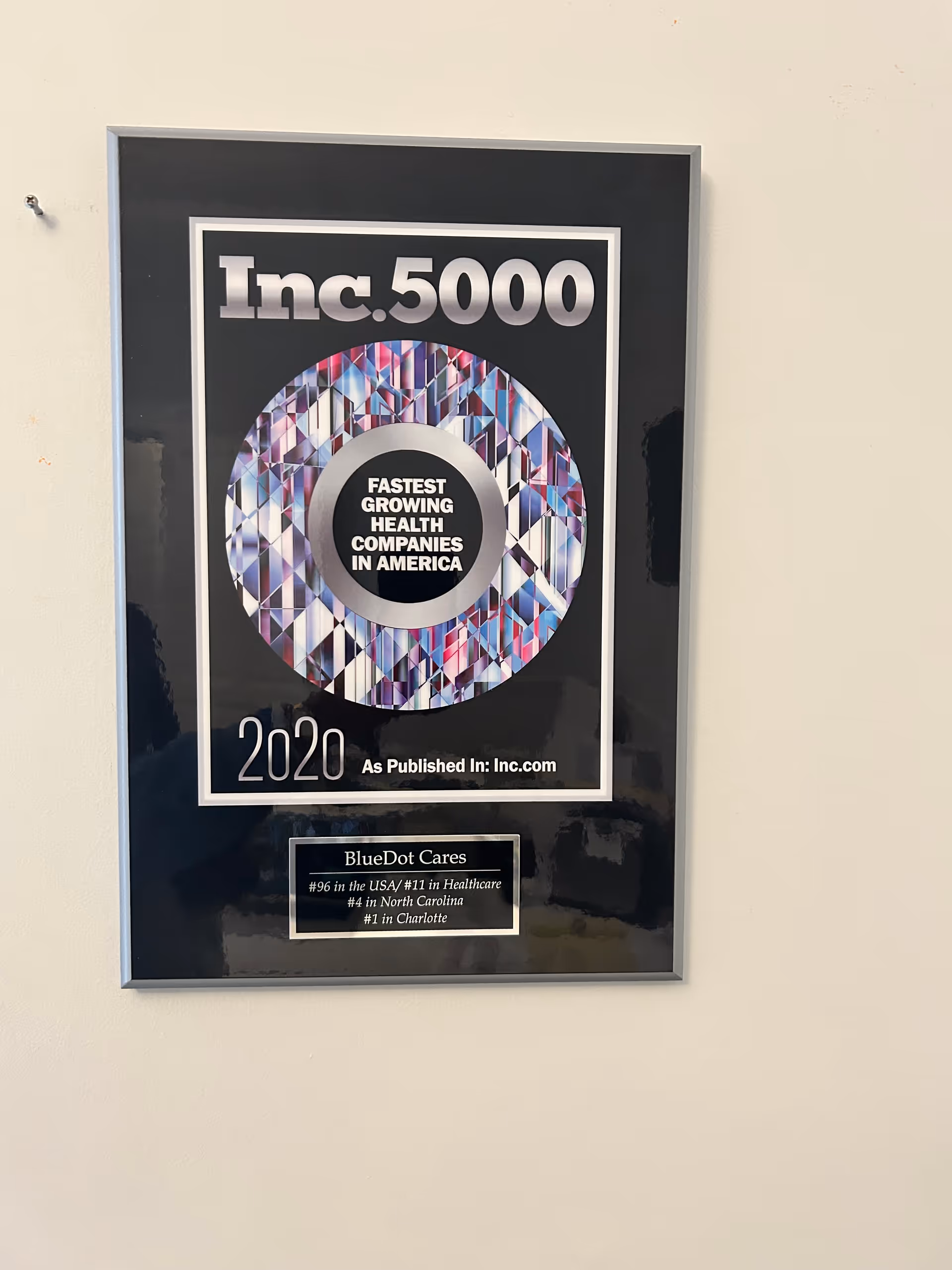 Framed Inc.5000 plaque on a wall with a BlueDot Cares plaque.