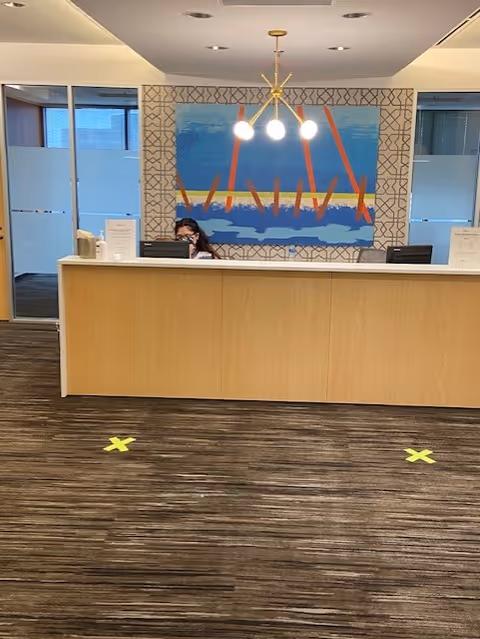 Reception desk inside a senior living lobby with staff and modern decor.