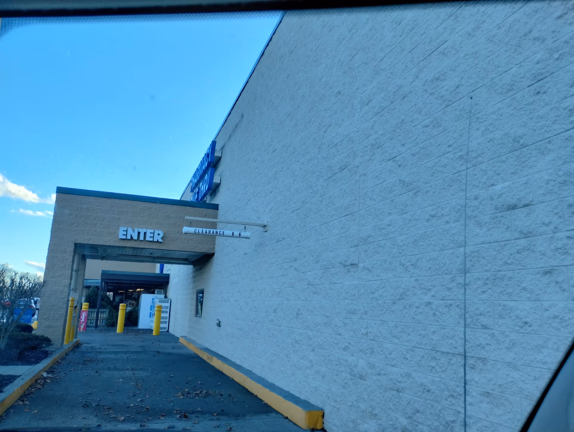Exterior view of a Kroger Pharmacy entrance with a walkway and blue sky
