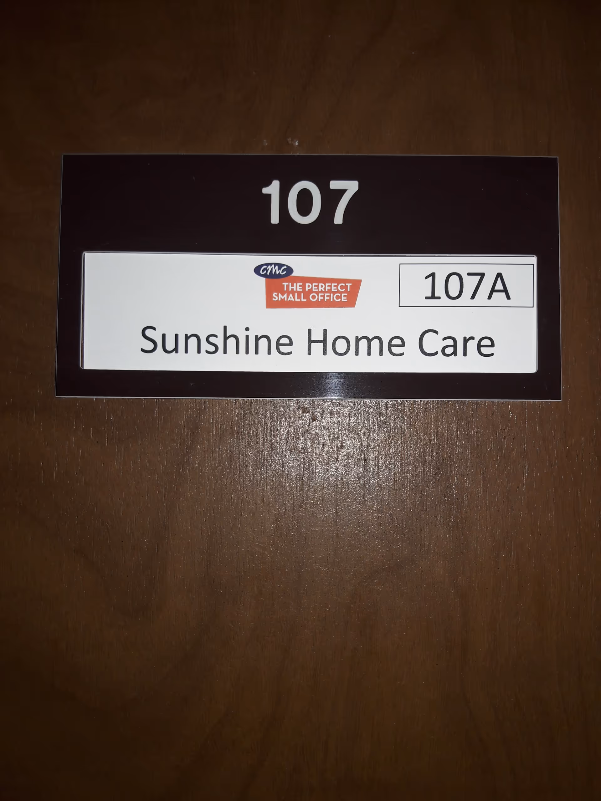 Wooden door sign displaying room 107A for Sunshine Home Care