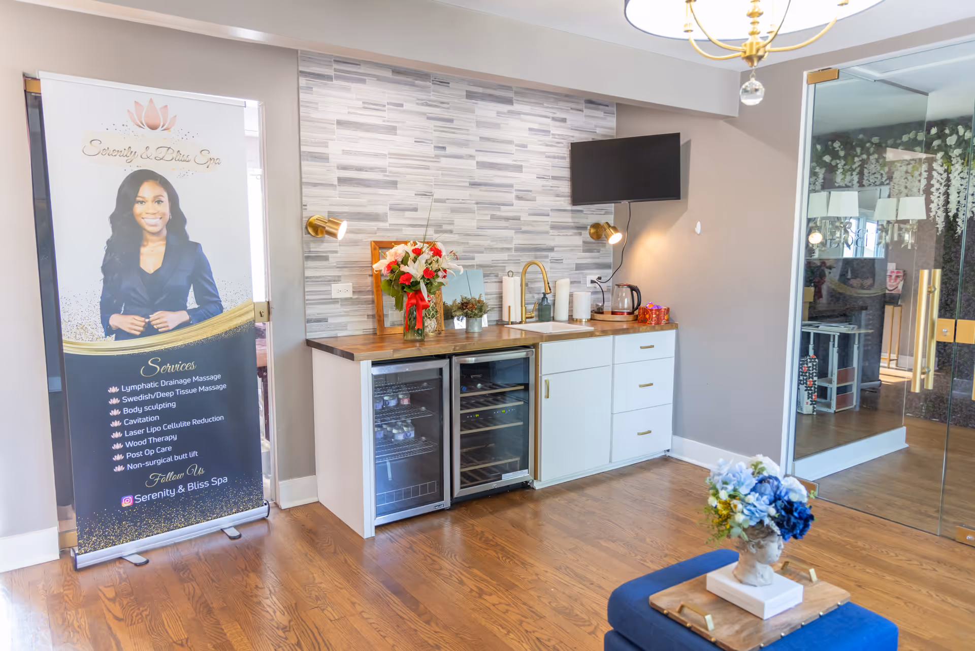 Modern interior lounge with kitchenette, a promotional banner, seating area, and glass door.