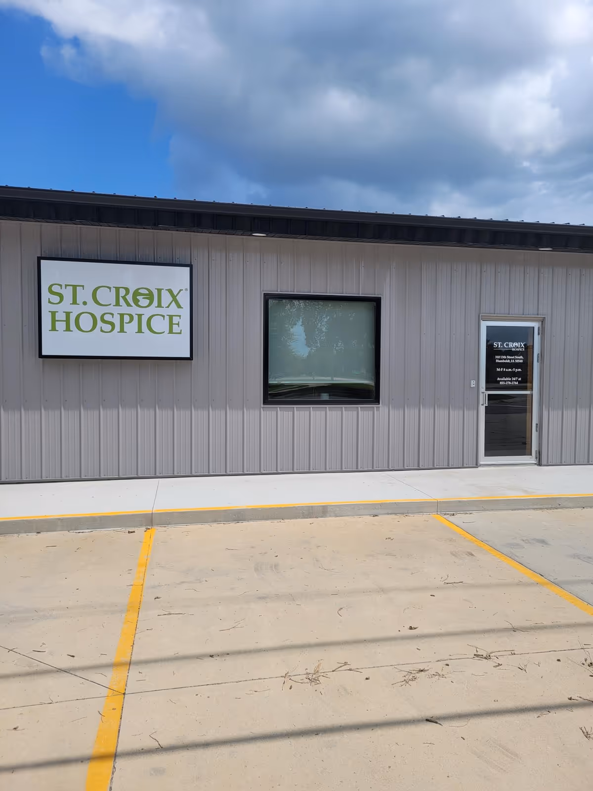 Exterior view of St. Croix Hospice building with sign and glass door.