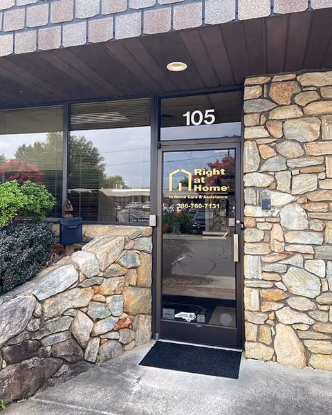 Stone exterior entry with glass door labeled 105 and Right at Home logo.