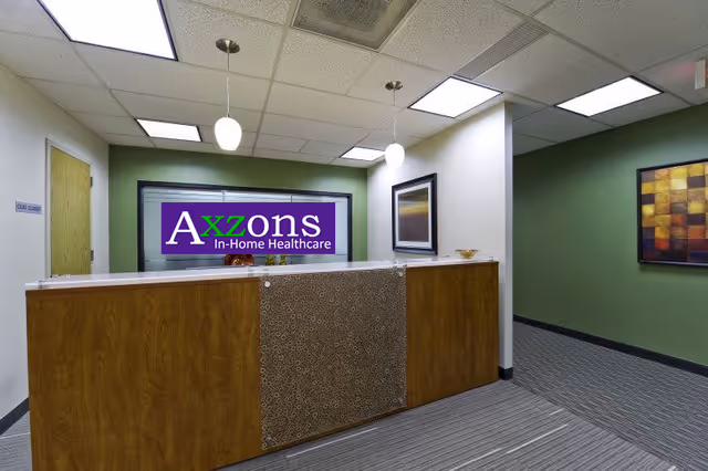 Reception desk in a hallway featuring the Axzons In-Home Healthcare sign.