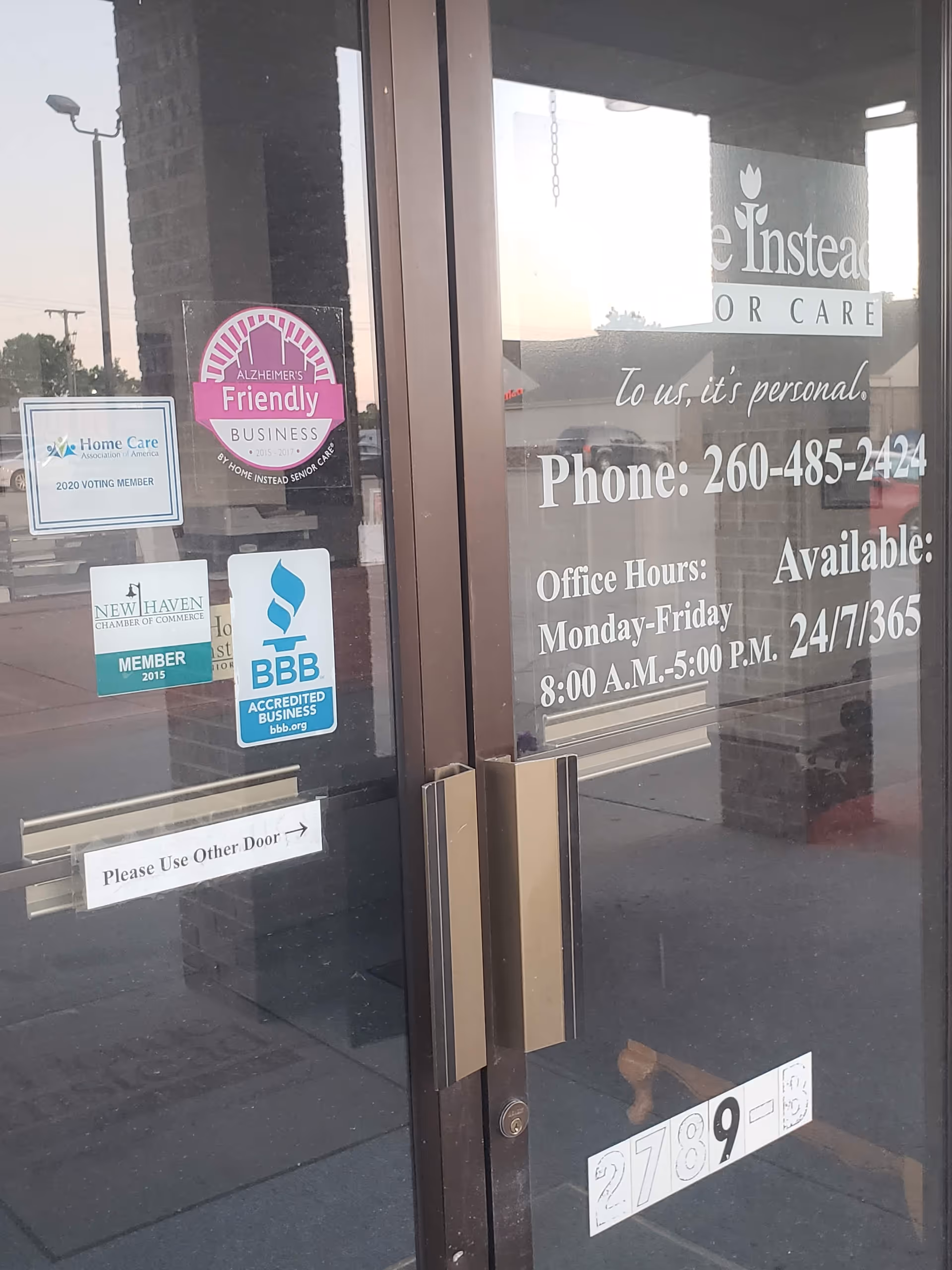 Entrance glass doors of Home Instead Senior Care with stickers and signage.