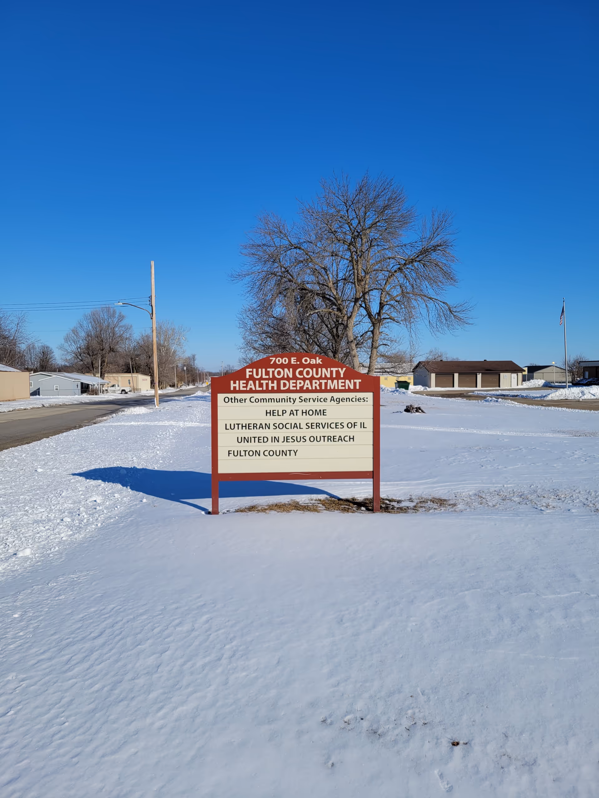 Snowy outdoor scene with a sign for Fulton County Health Department Help at Home.