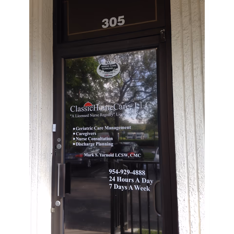 Glass door displaying Classic HomeCare LLC signage and contact details at the building entrance.