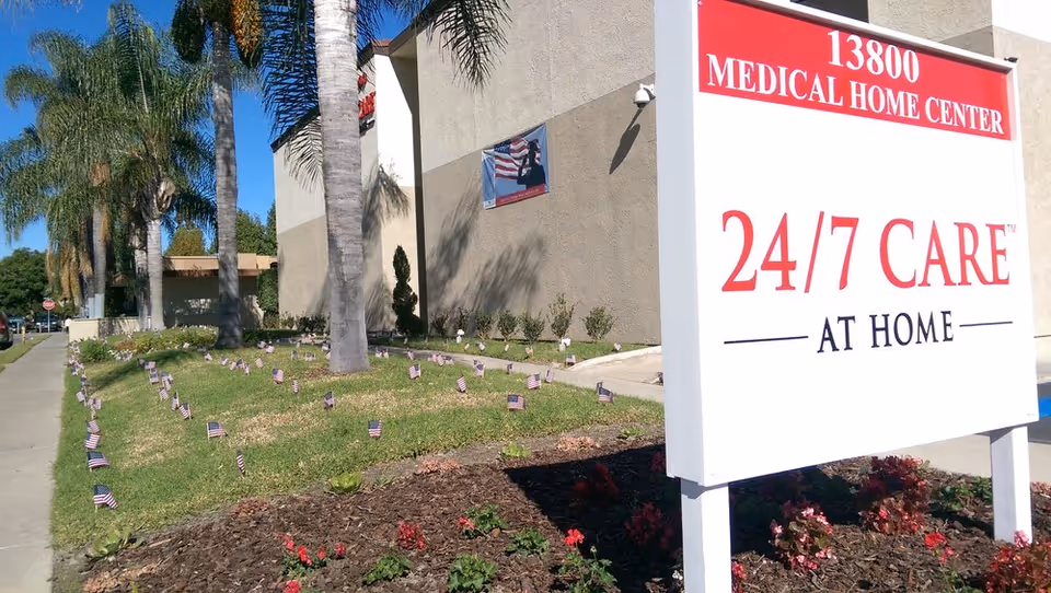 Exterior view of a medical home center with a large front sign and palm trees.