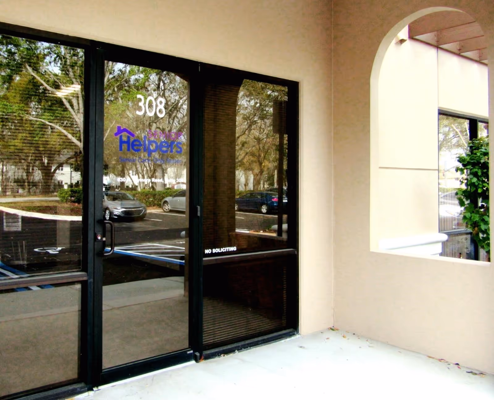 Entrance to Senior Helpers facility with glass doors and logo, address 308.