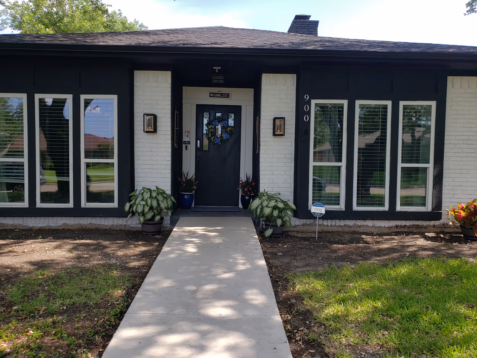 Front entrance of Integrity Residential Care, LLC, with walkway and decorative plants.