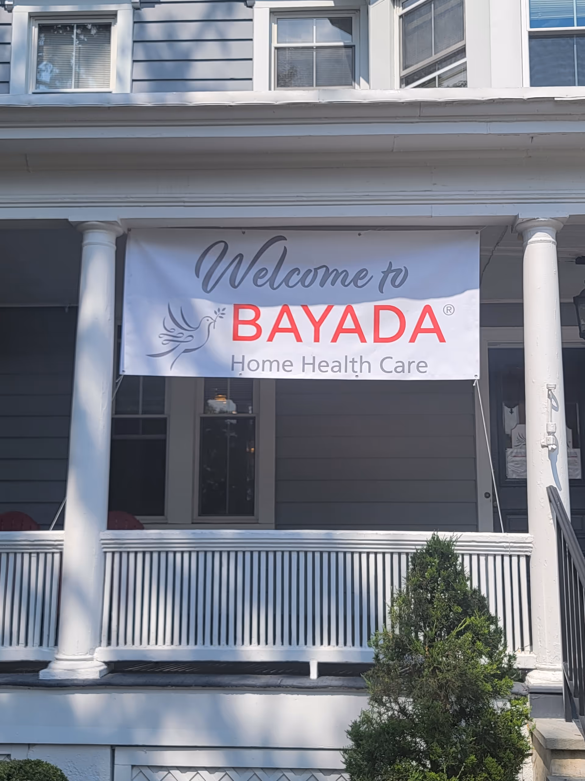 Front porch of a building with white columns and a BAYADA Home Health Care banner.