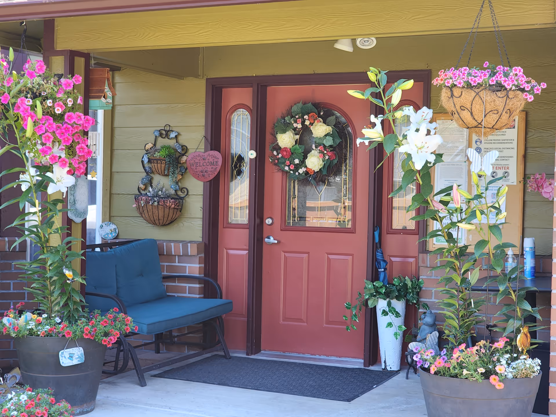 Front porch entrance of Green Haven Home Care LLC with floral decorations and seating.