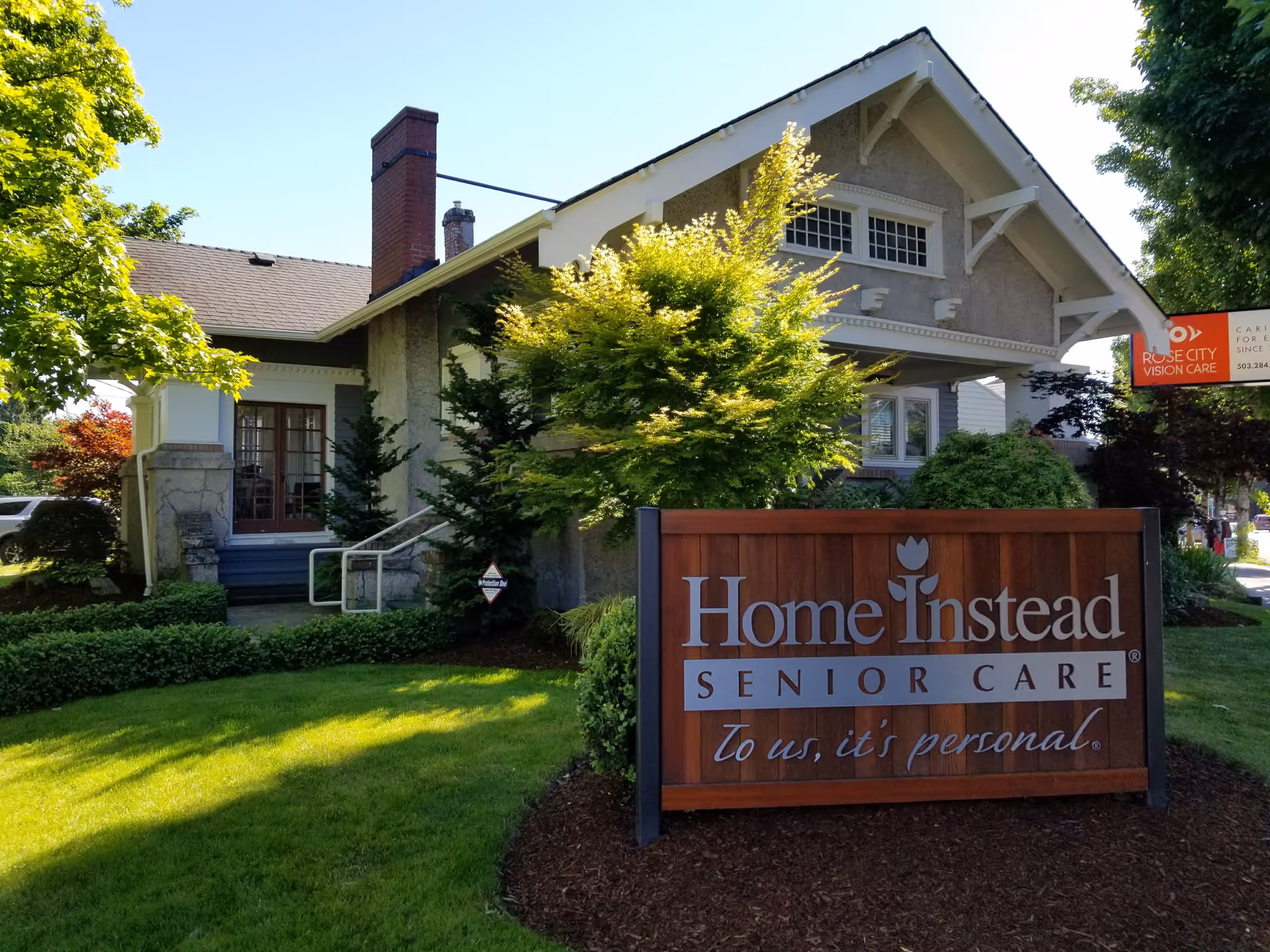 Front view of a Home Instead Senior Care building with a wooden sign.