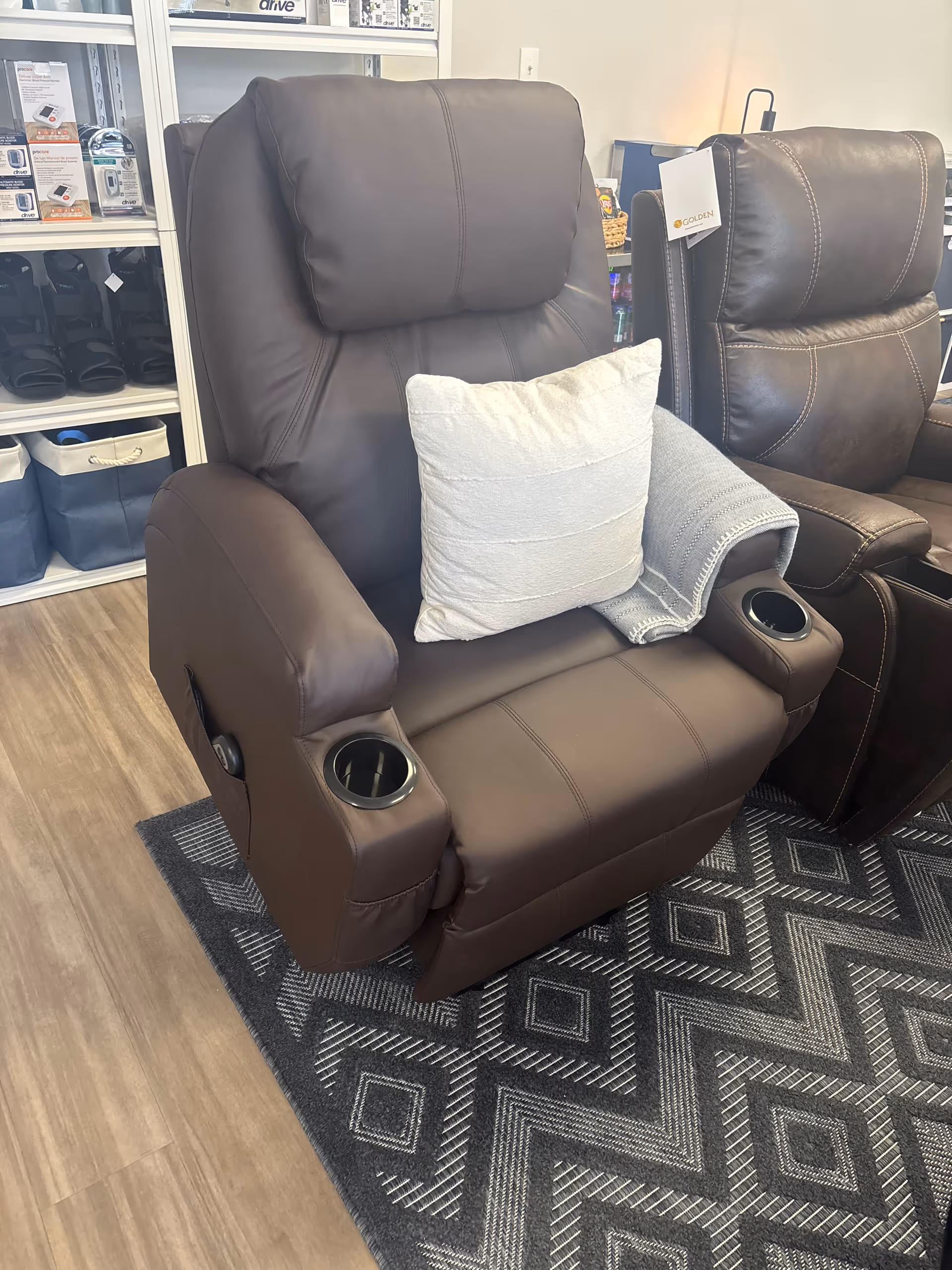 Two brown reclining chairs with cup holders in a showroom display.