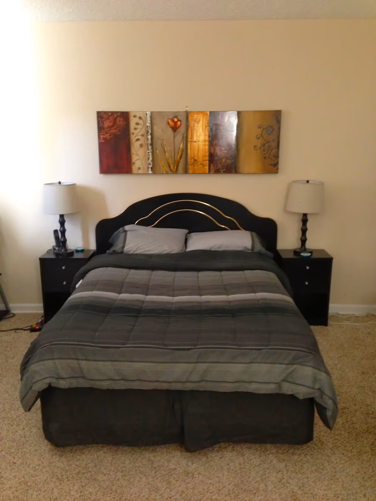 A neatly made bed with matching nightstands and lamps in a bedroom.