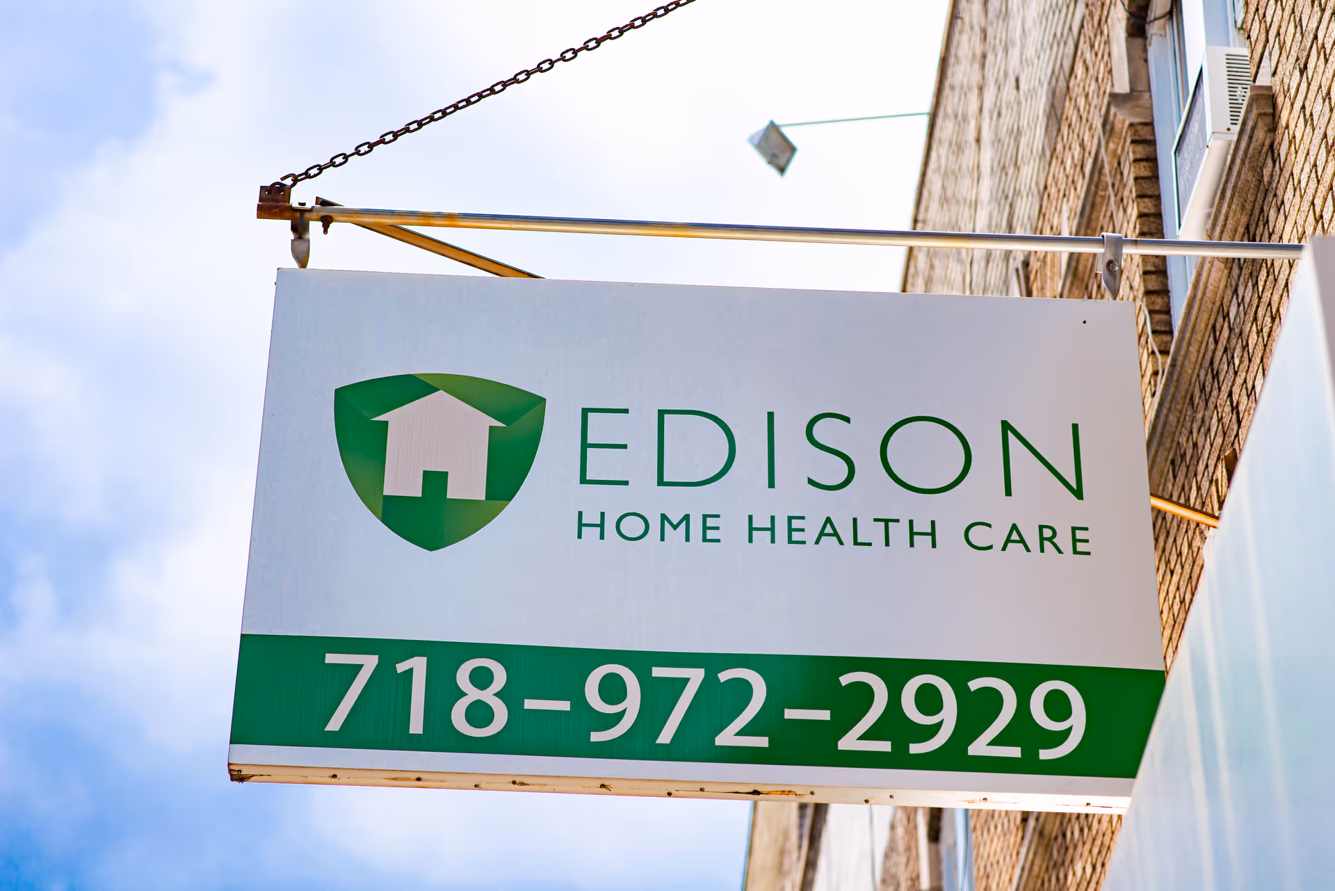 Exterior sign for Edison Home Health Care with a green logo on a brick building.