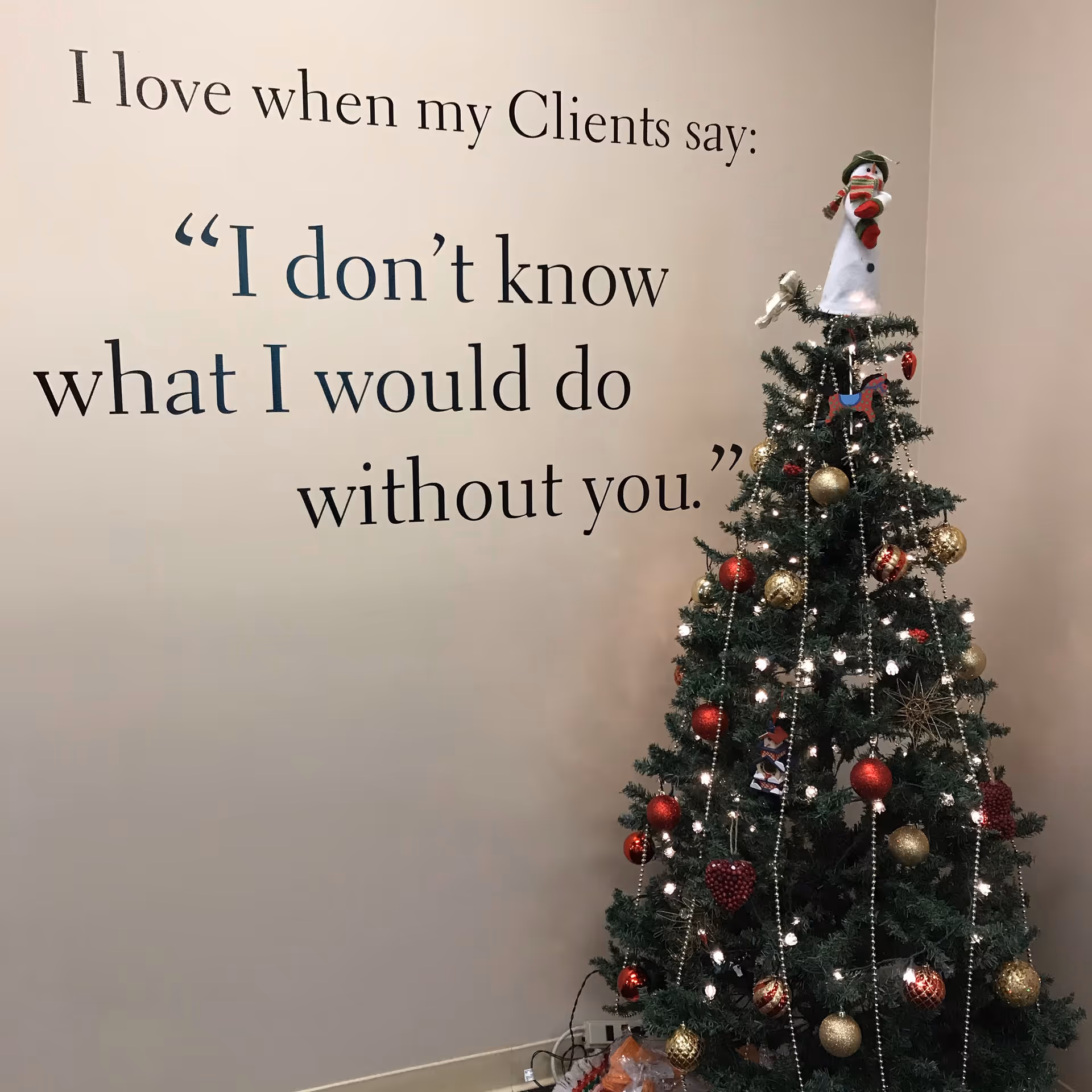 Interior wall features a large quote beside a decorated Christmas tree.