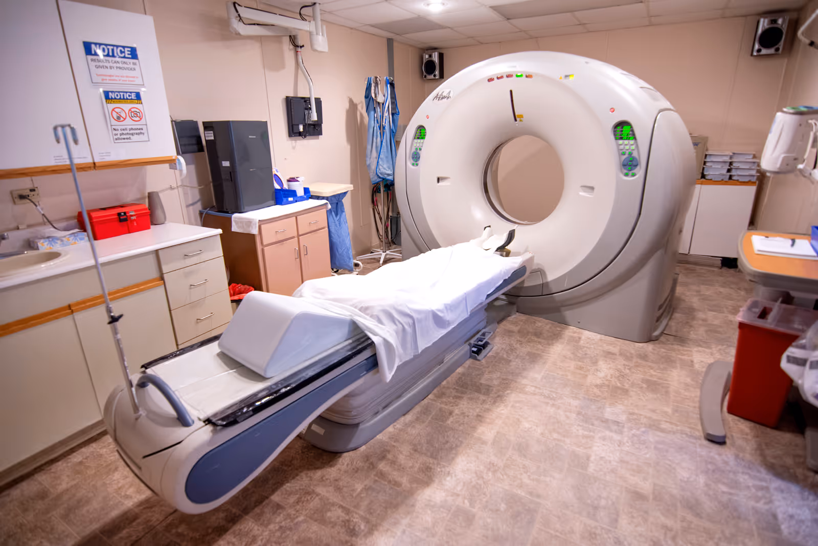 Interior imaging room with a CT scanner and patient bed.