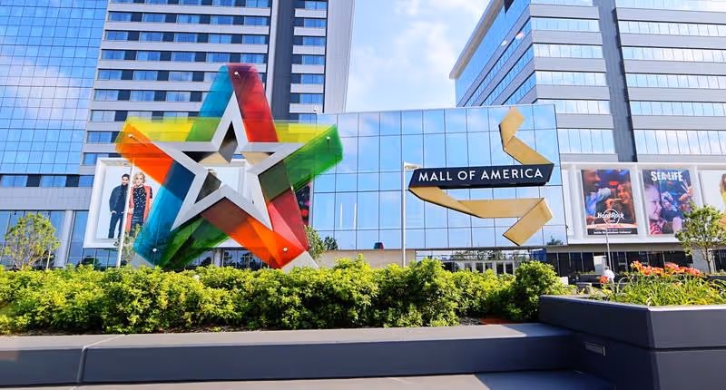 Colorful rainbow star sculpture in front of the Mall of America exterior.
