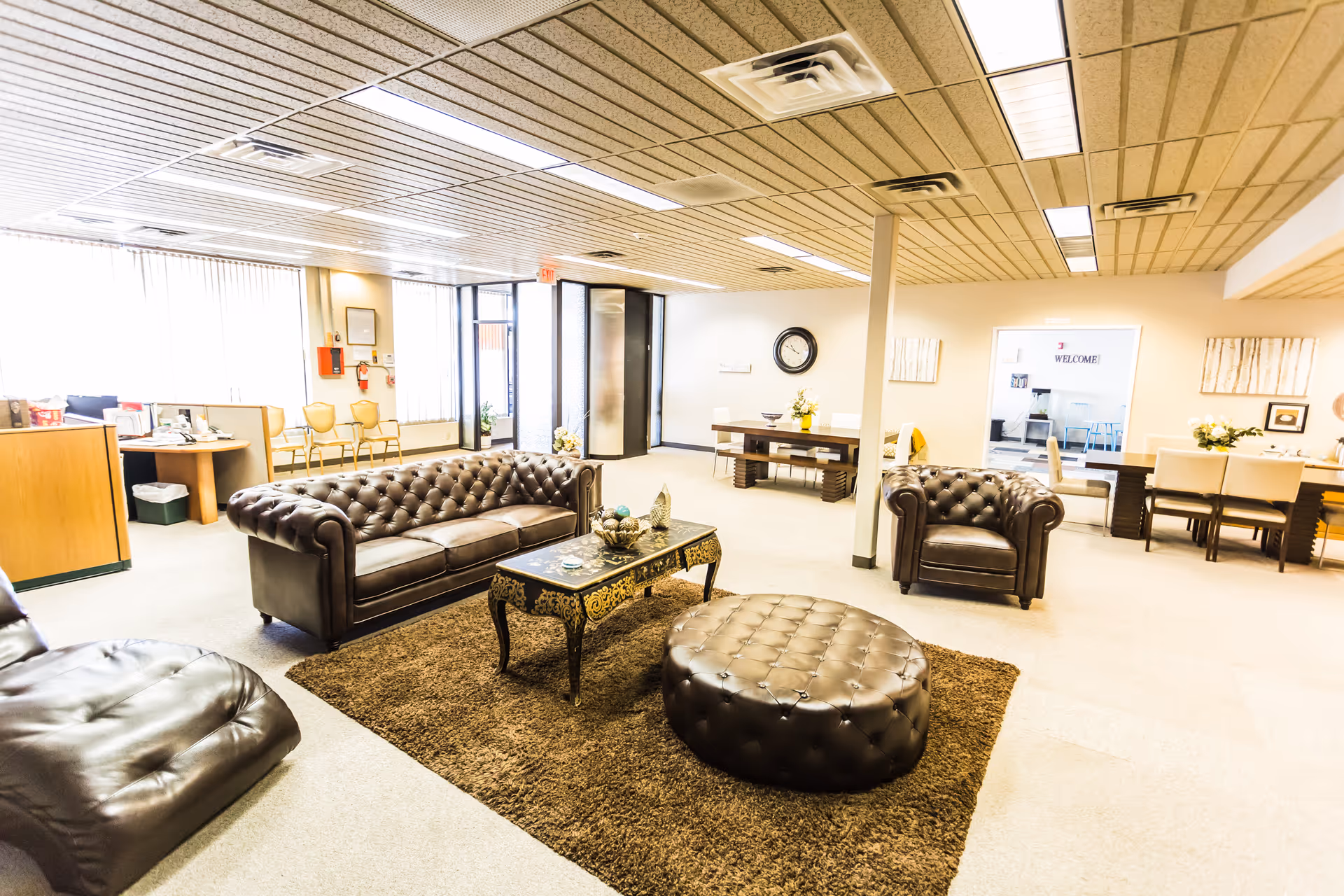 Spacious lounge area with leather sofas, an ottoman, and a coffee table.