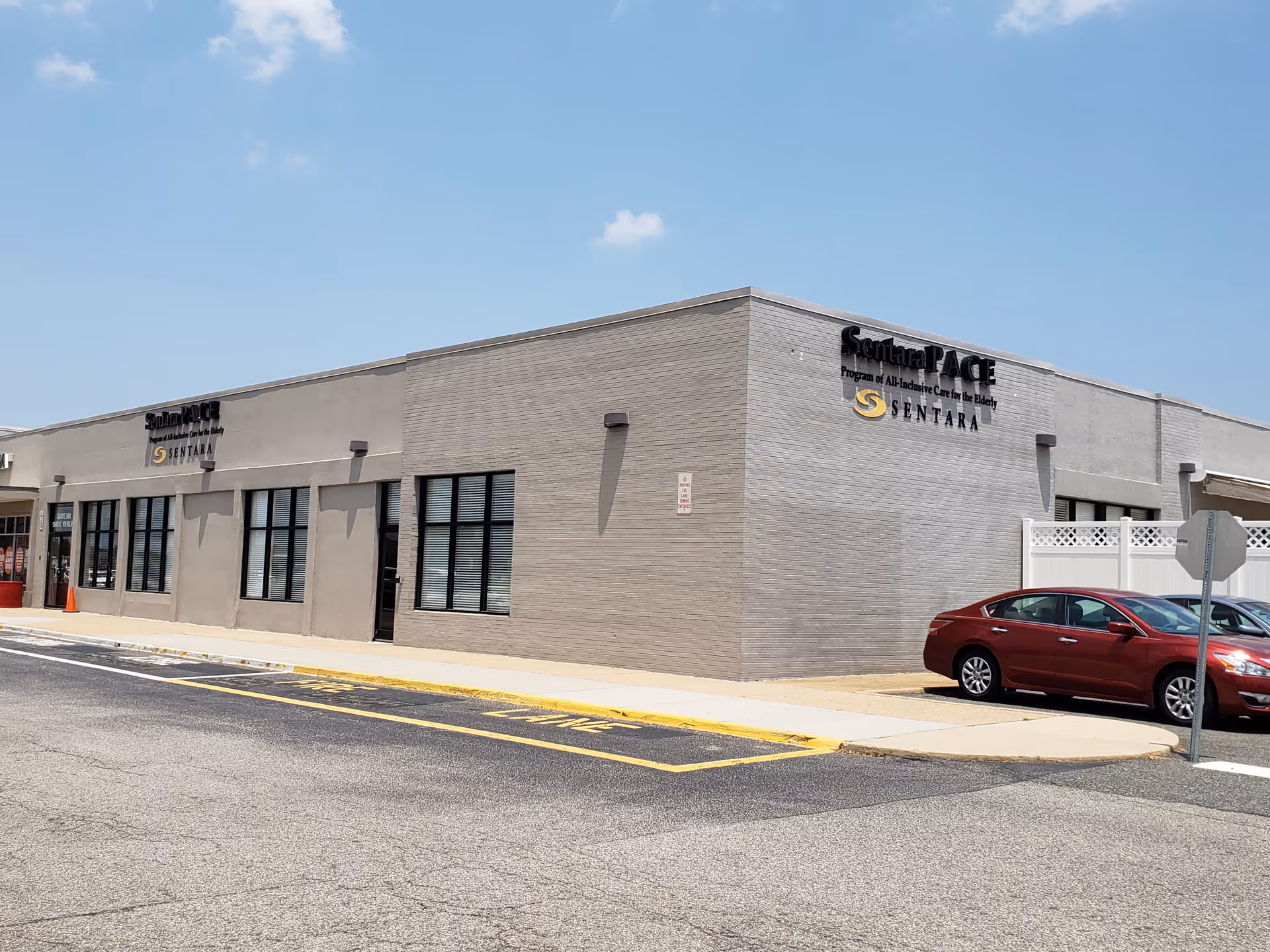 Exterior view of a Sentara PACE building with a red car parked in front.