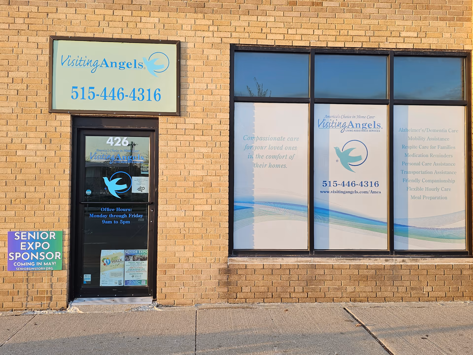 Brick building storefront with Visiting Angels Senior Home Care signage and window graphics.