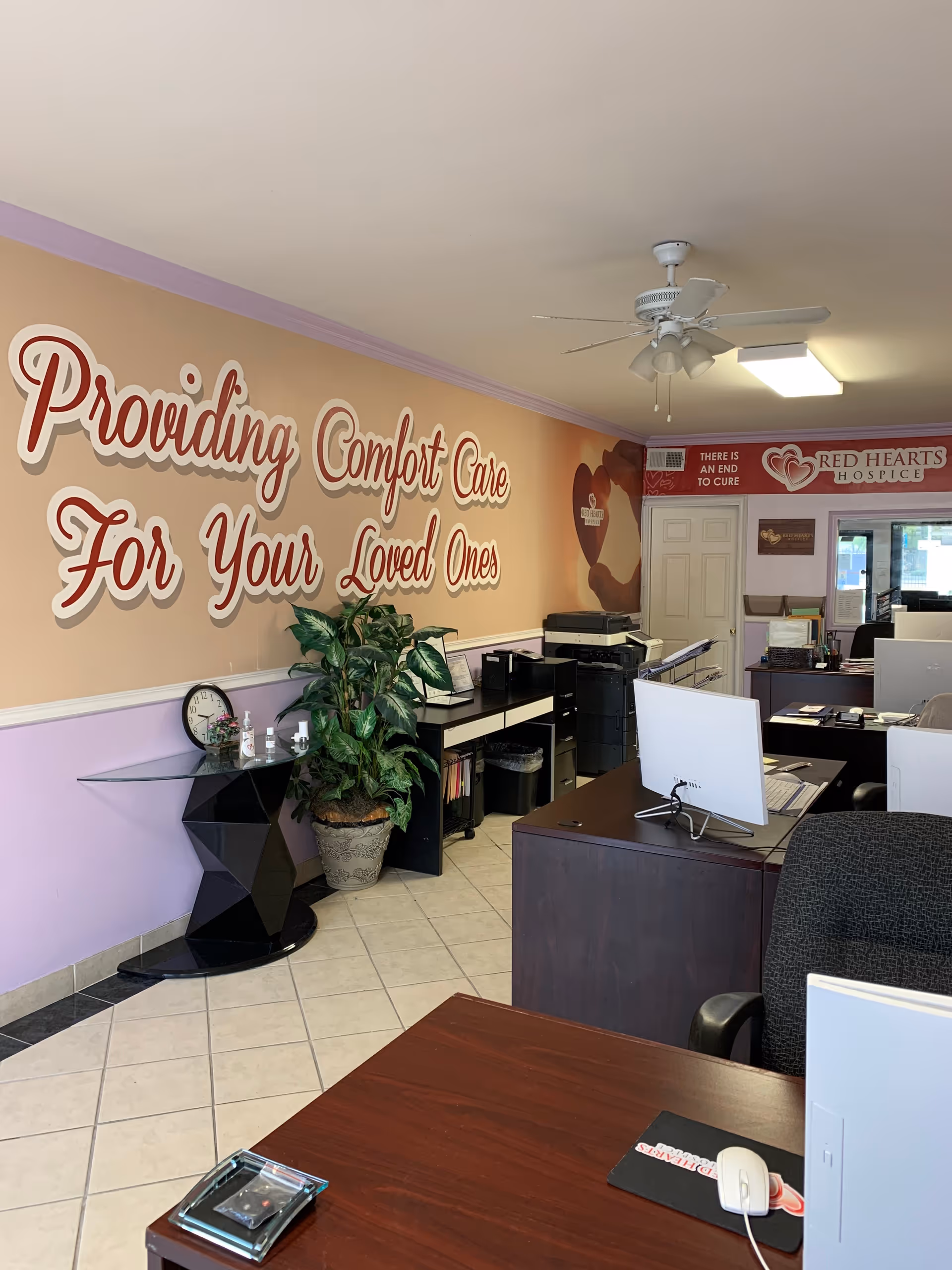 Reception area of Red Hearts Hospice with desks, computers, and a large wall mural.