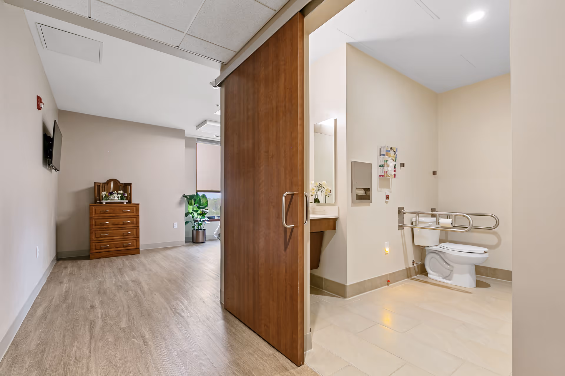 Interior hallway with a bathroom entrance on the right and a wooden sliding door.