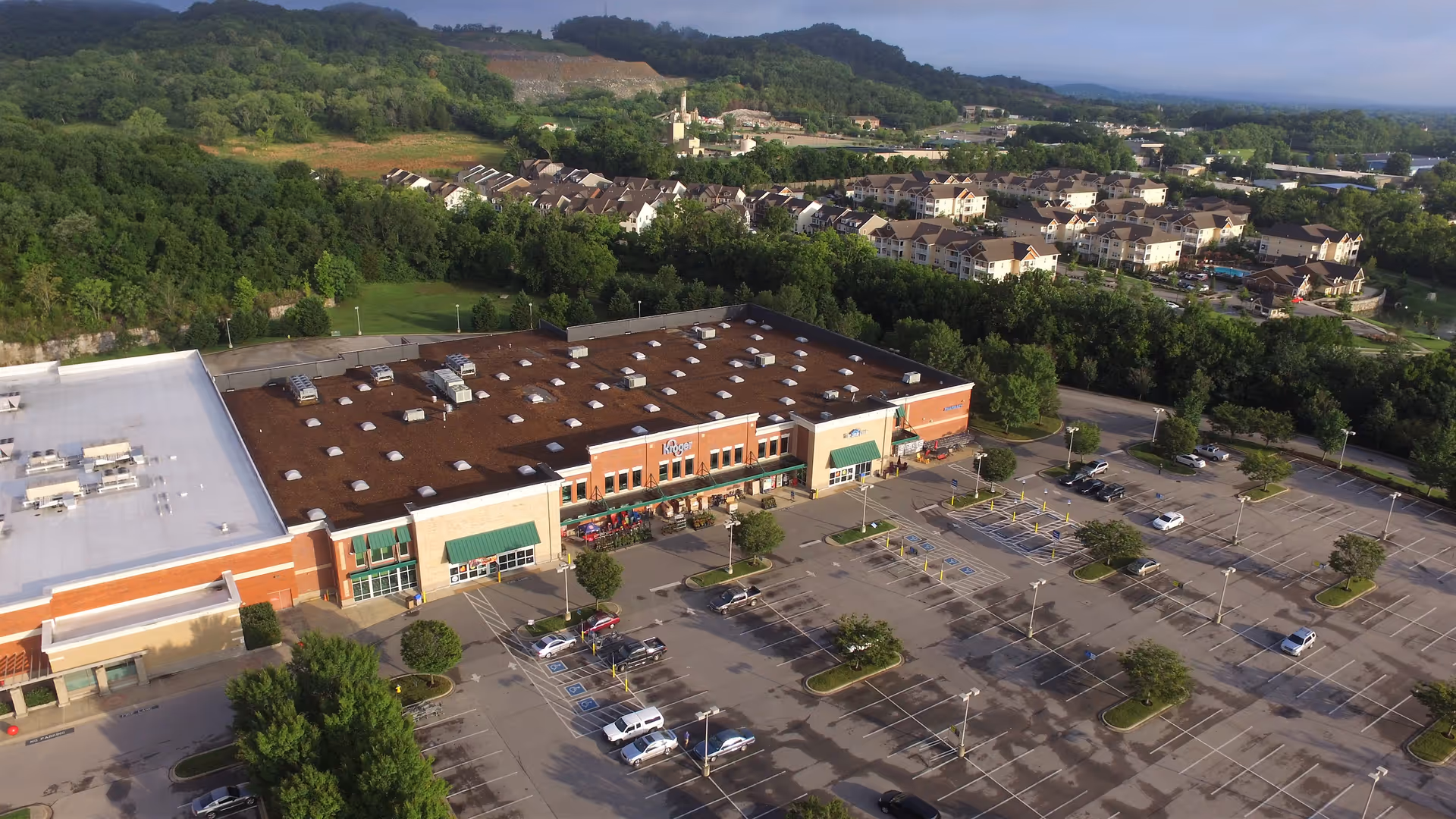 Aerial view of a Kroger Pharmacy shopping plaza with a large parking lot.