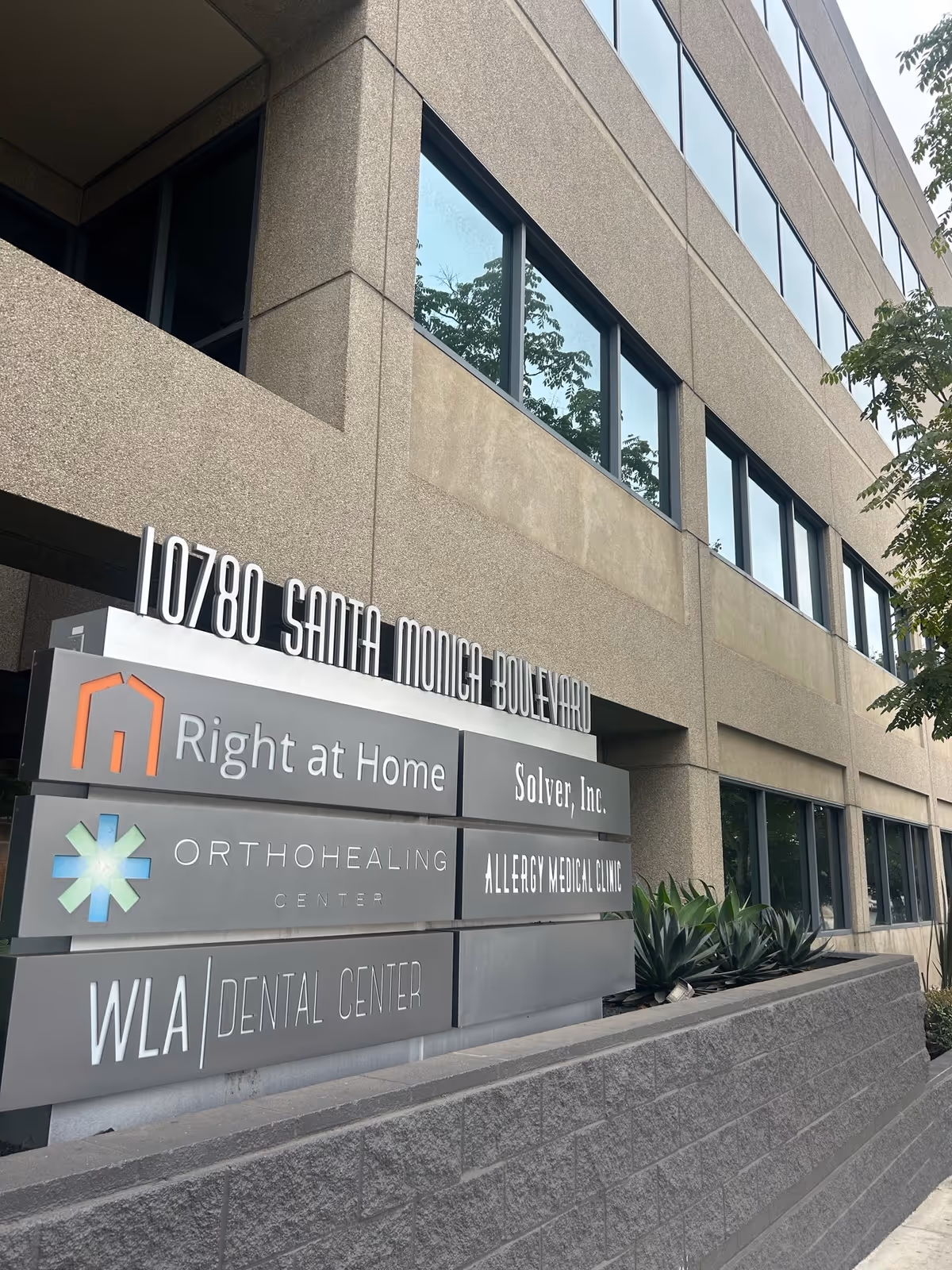 Exterior view of a multi-tenant building with Right at Home and medical center signage.