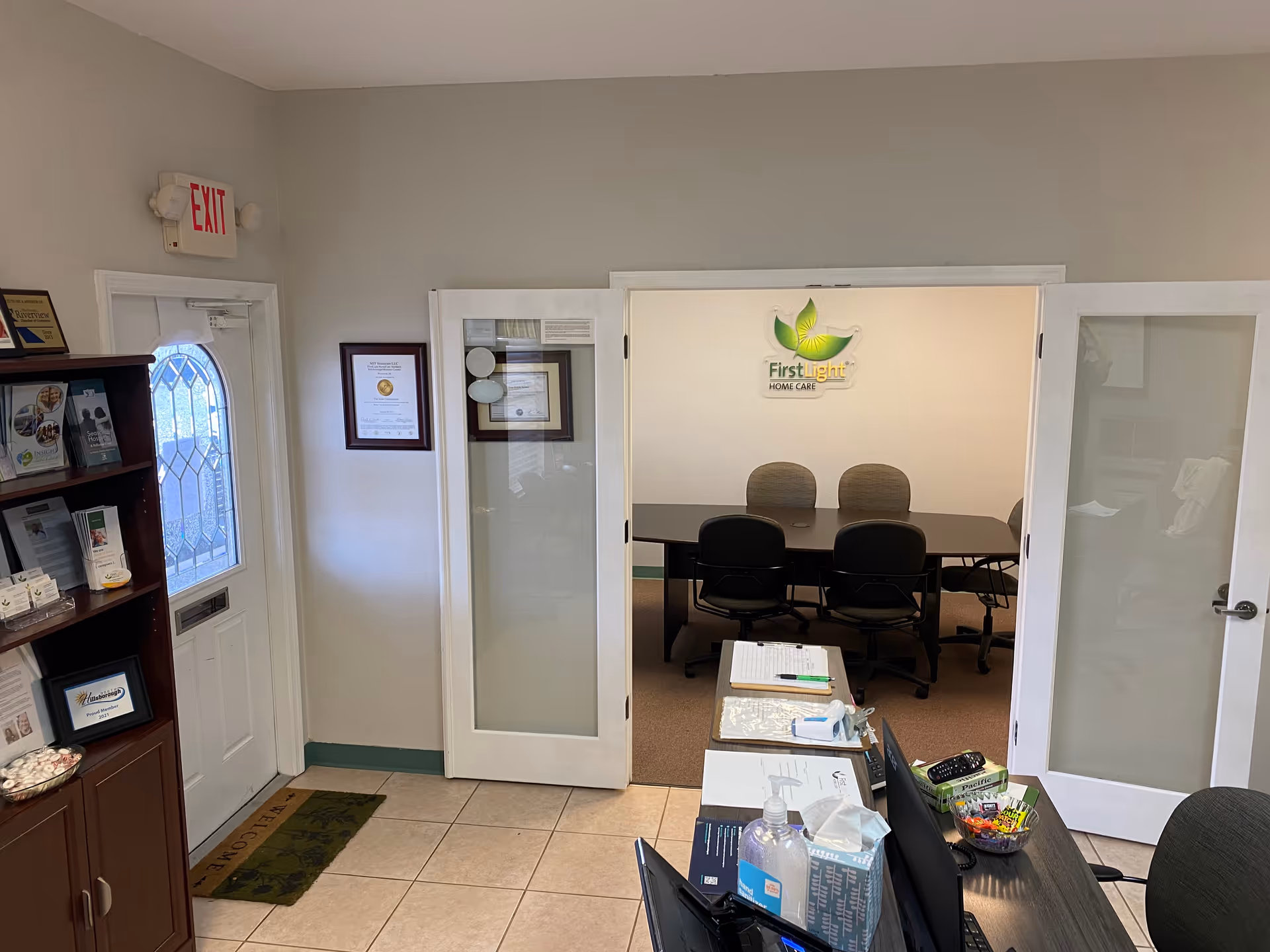 Reception area featuring a conference room door and FirstLight Home Care logo on wall.