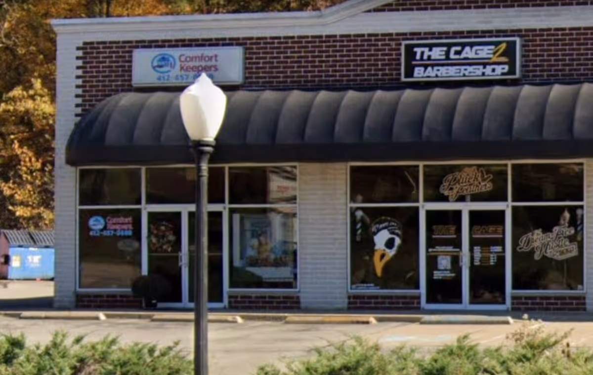 Front of a building featuring Comfort Keepers sign and The Cage Barbershop storefront.