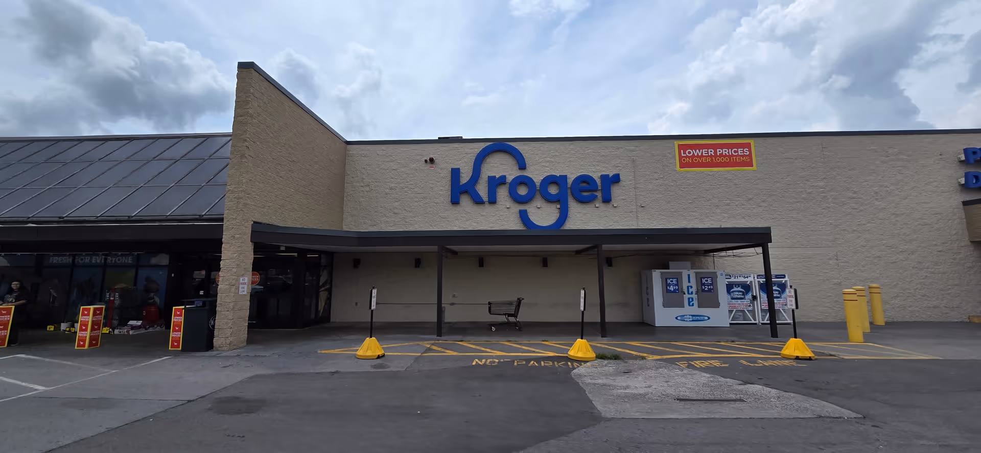 Front of a Kroger store with a blue Kroger sign and covered entrance.
