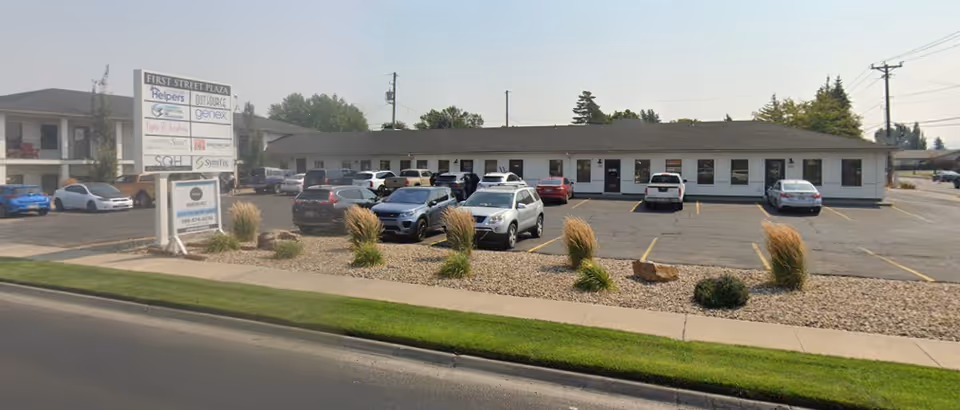 Exterior view of a single-story Senior Helpers facility with a parking lot.