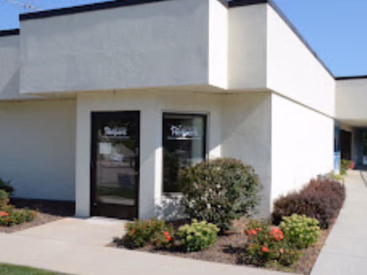 Exterior view of a Senior Helpers facility with entrance doors and landscaped shrubs.